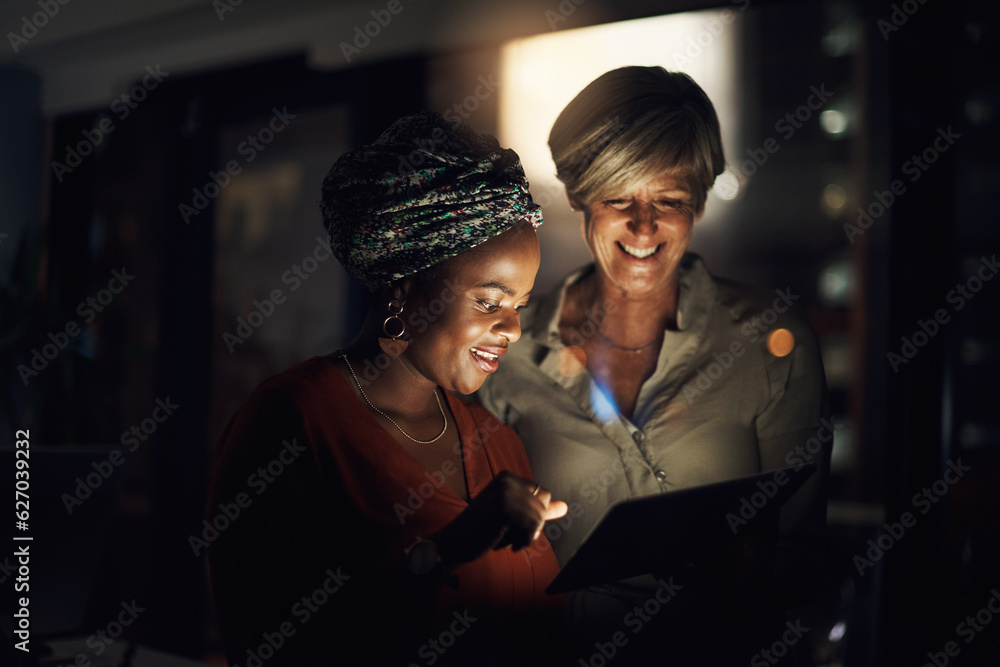 Optimising their time with technology. Shot of two businesswomen using a digital tablet together in 