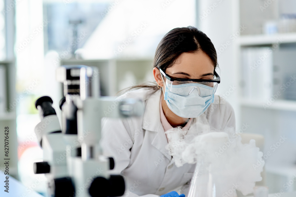 The world of science is so intriguing. Shot of a young scientist doing an experiment in a lab.