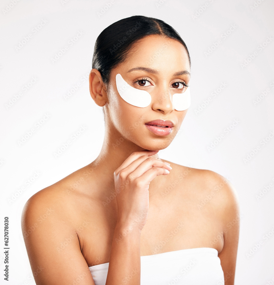 Woman, portrait and eye patches for skincare, beauty or cosmetics against a white studio background.