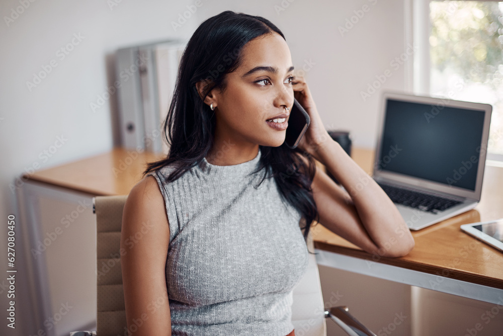 Success is calling her once again. Shot of a young businesswoman talking on a cellphone in an office