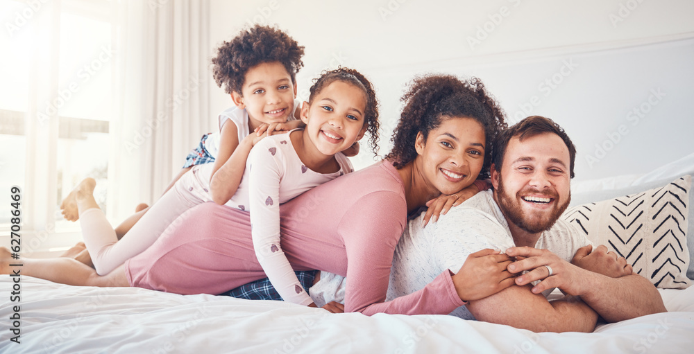 Interracial, happy family and portrait on a bed, bond and having fun on the weekend in their home to