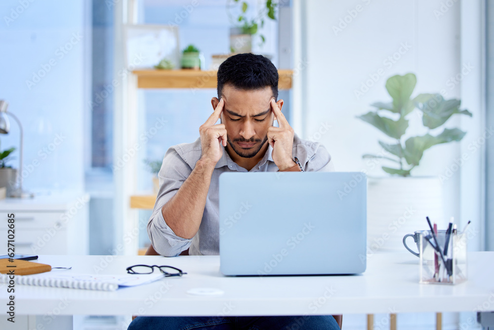 Mental health, businessman with a headache and laptop on his desk in office at workplace. Anxiety or