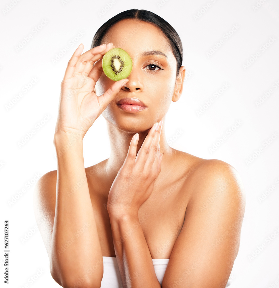 Woman, portrait and face with kiwi for vitamin C, diet or skincare against a white studio background