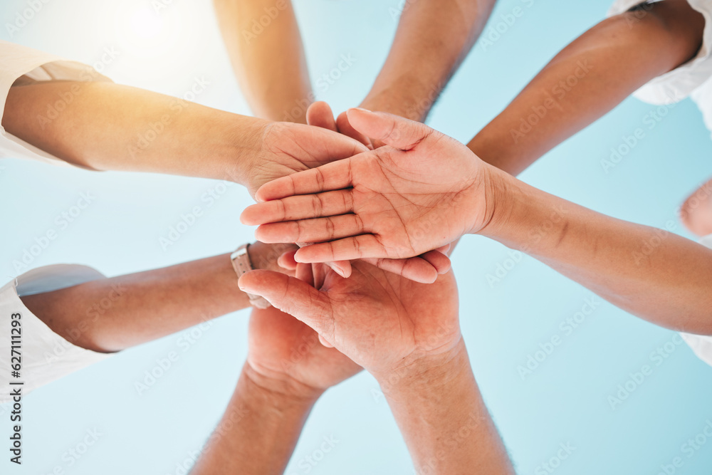 Circle, low angle and team with hands together for collaboration, unity or support by a blue sky. Te