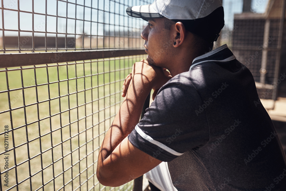 Nothing hypnotises him like baseball. Shot of a young man watching a game of baseball from behind th