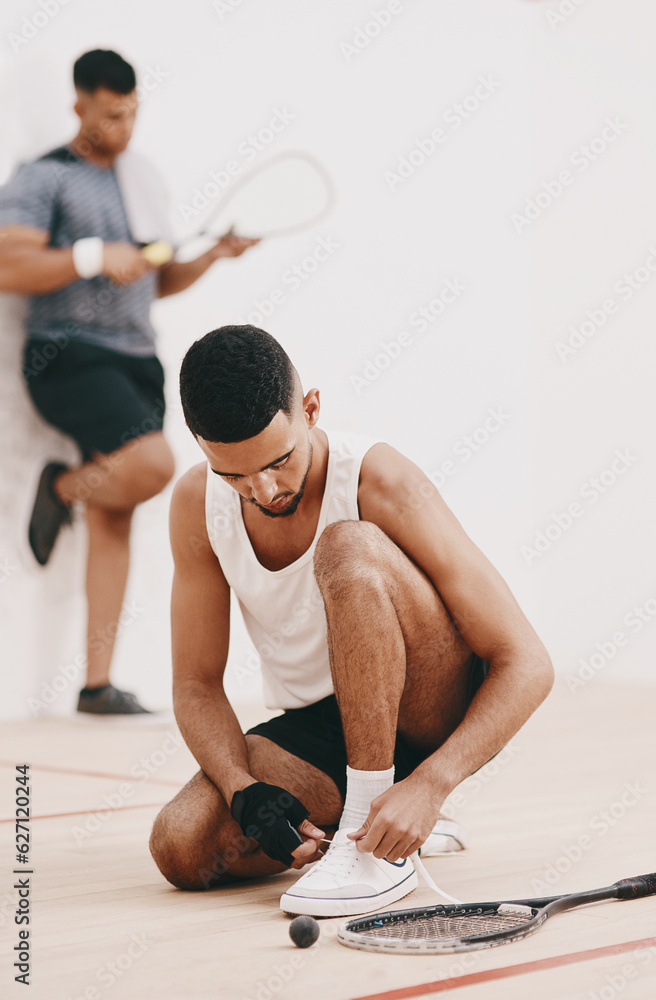 The countdown to squash awesomeness. Shot of a young man tying his shoelaces before a game of squash