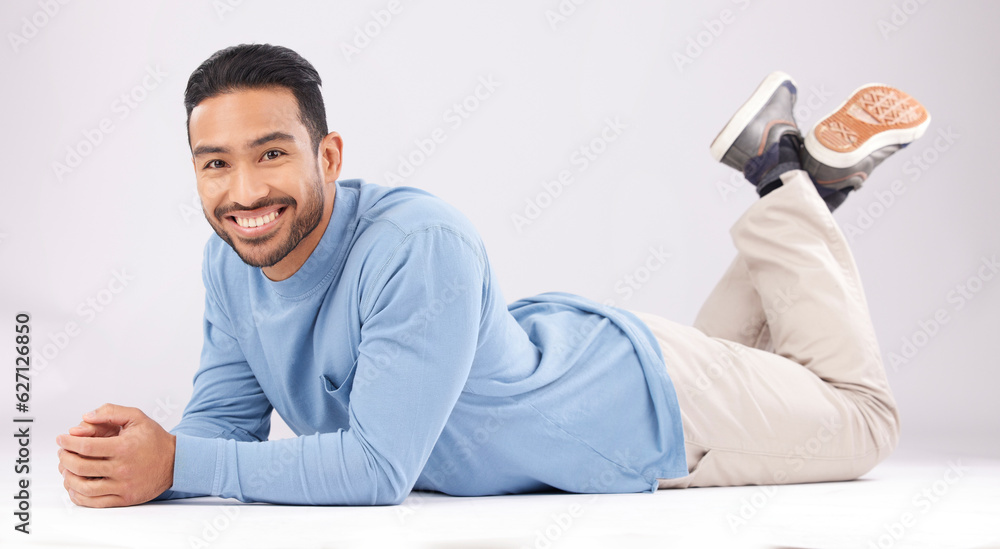 Fashion, portrait and happy man on the floor in studio isolated on a white background. Style, smile 