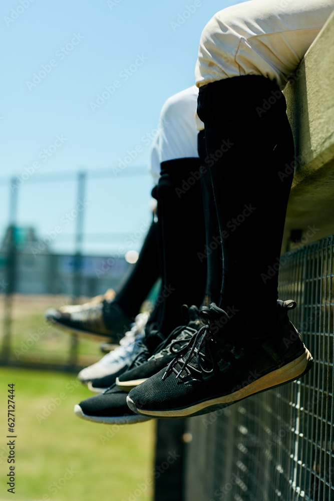 Watching the game from the field. Cropped shot of a team of unrecognizable baseball players sitting 