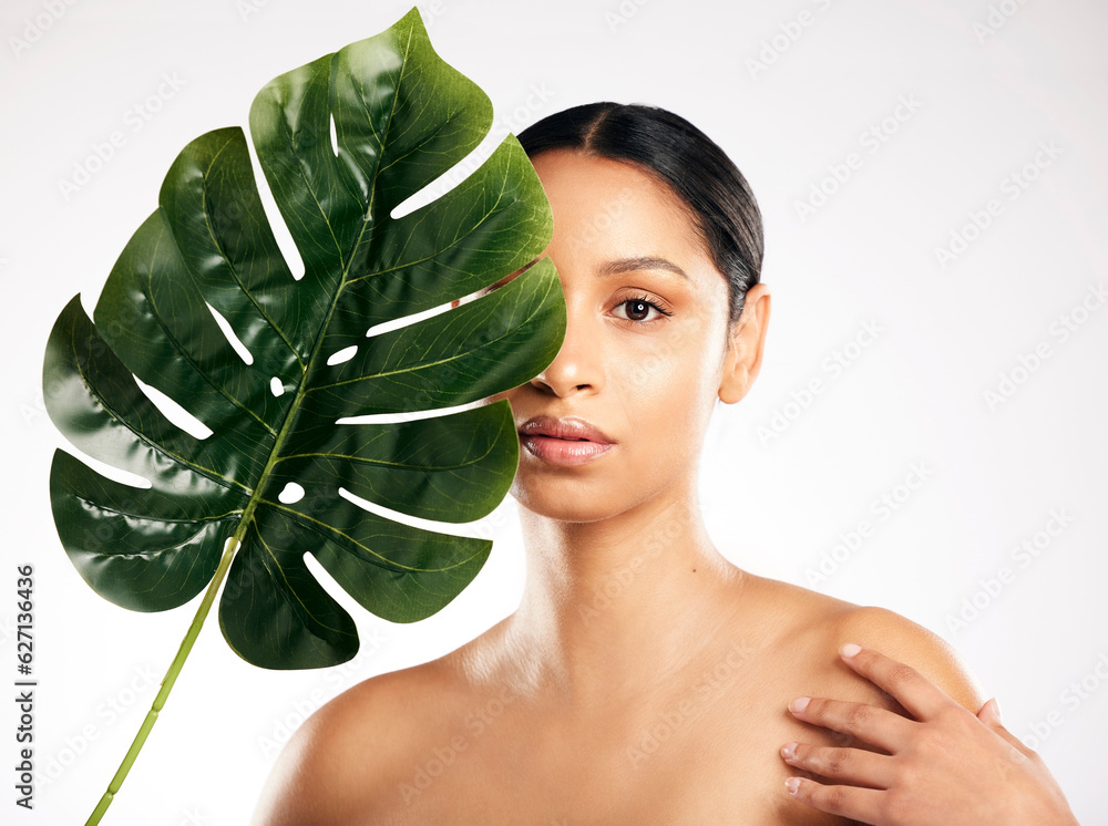 Woman, portrait and leaf for natural beauty, skincare or organic cosmetics against a white studio ba