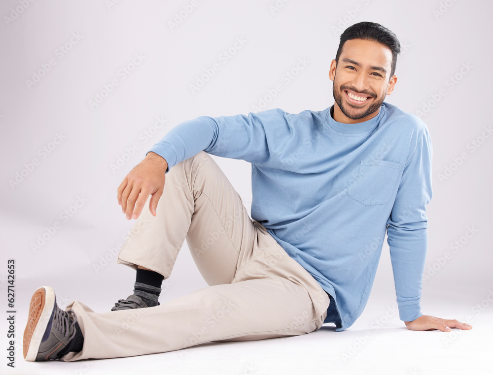 Portrait, fashion and happy man on the floor in studio isolated on a white background. Style, smile 