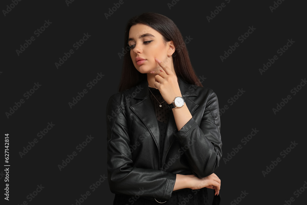 Stylish beautiful woman with wristwatch on black background