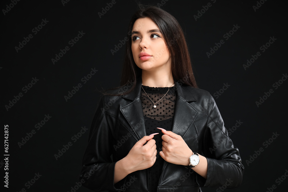 Stylish beautiful woman with wristwatch on black background