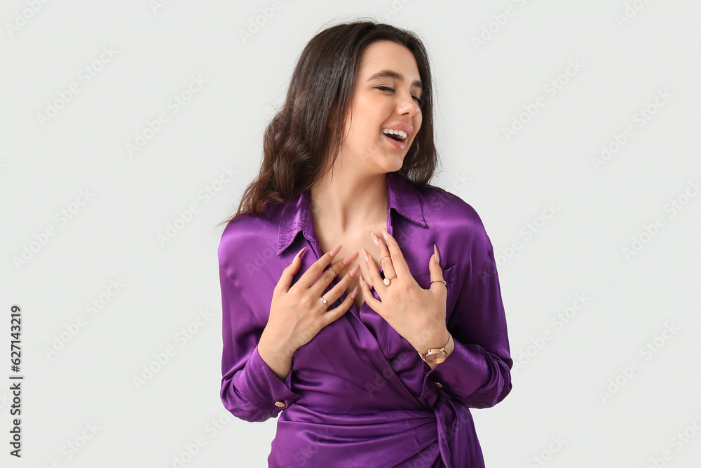 Elegant beautiful young woman with wristwatch on grey background