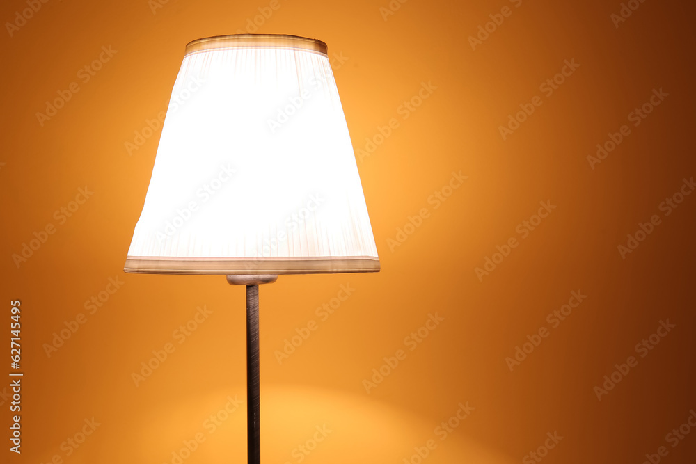 Glowing lamp on wooden table in dark room