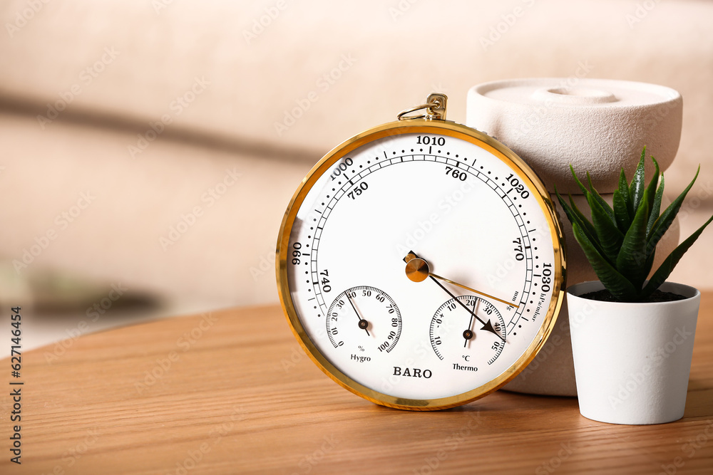 Aneroid barometer on wooden table in room, closeup