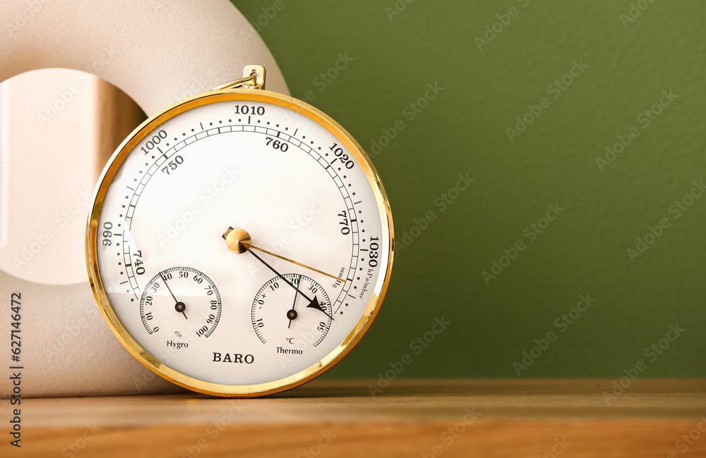 Aneroid barometer on wooden table in room, closeup