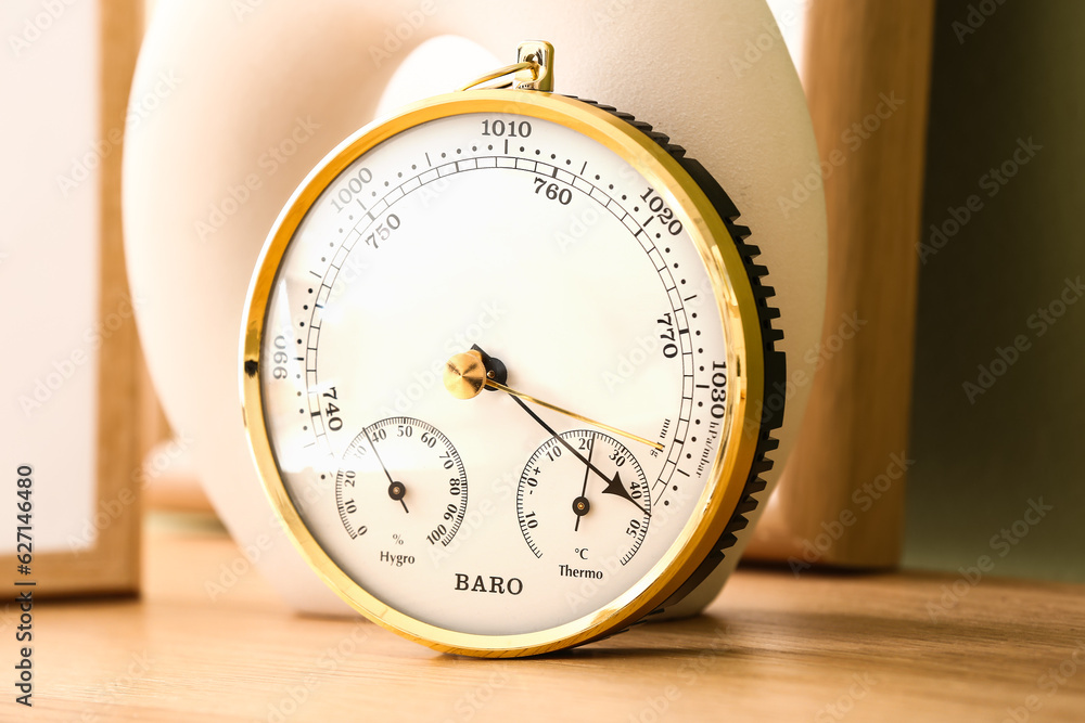 Aneroid barometer on wooden table in room, closeup