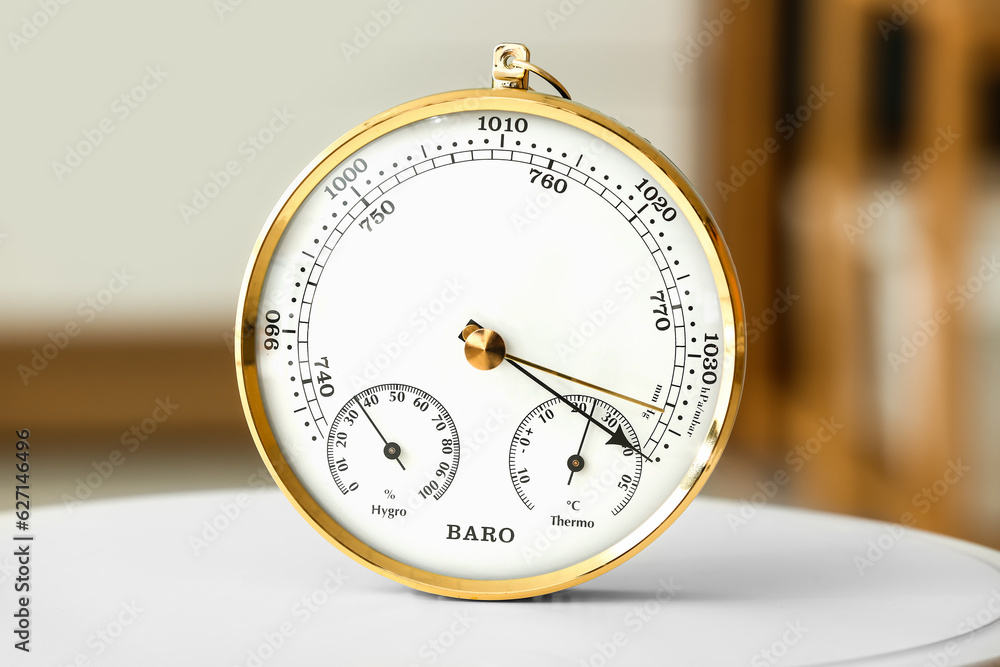 Aneroid barometer on white table in room, closeup