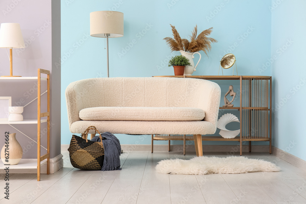 Interior of living room with white sofa, fur rug and shelving unit