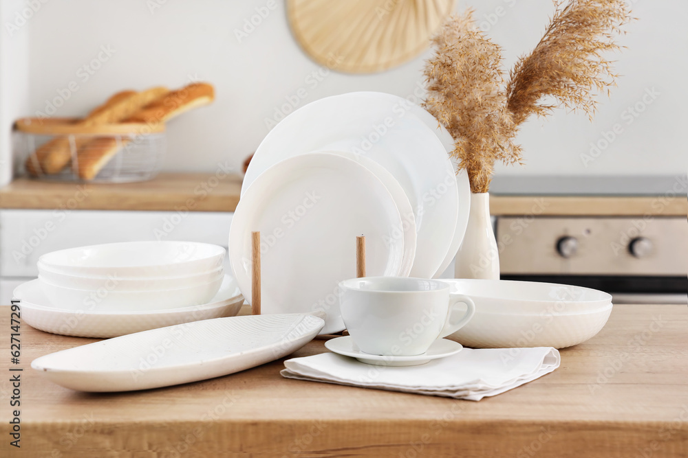 Set of clean dishes on wooden countertop in kitchen, closeup