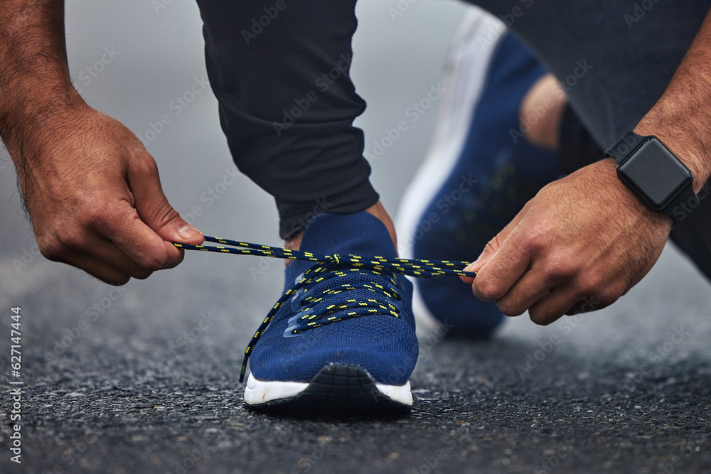 Man, hands and tie shoes on road for running, fitness or cardio workout on asphalt in the outdoors. 