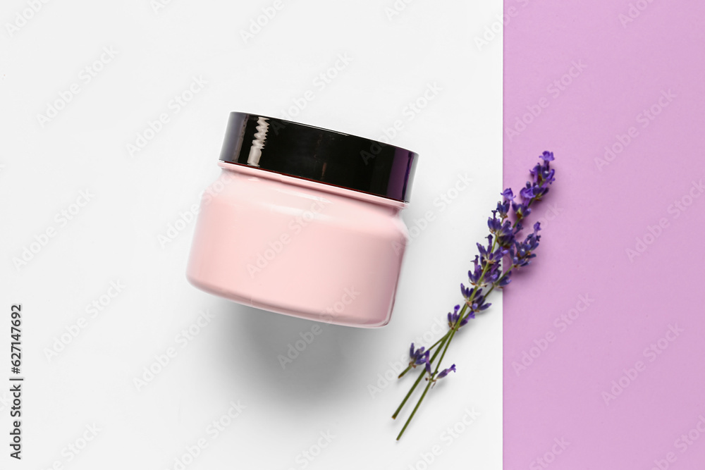 Jar of cosmetic product and lavender flowers on color background