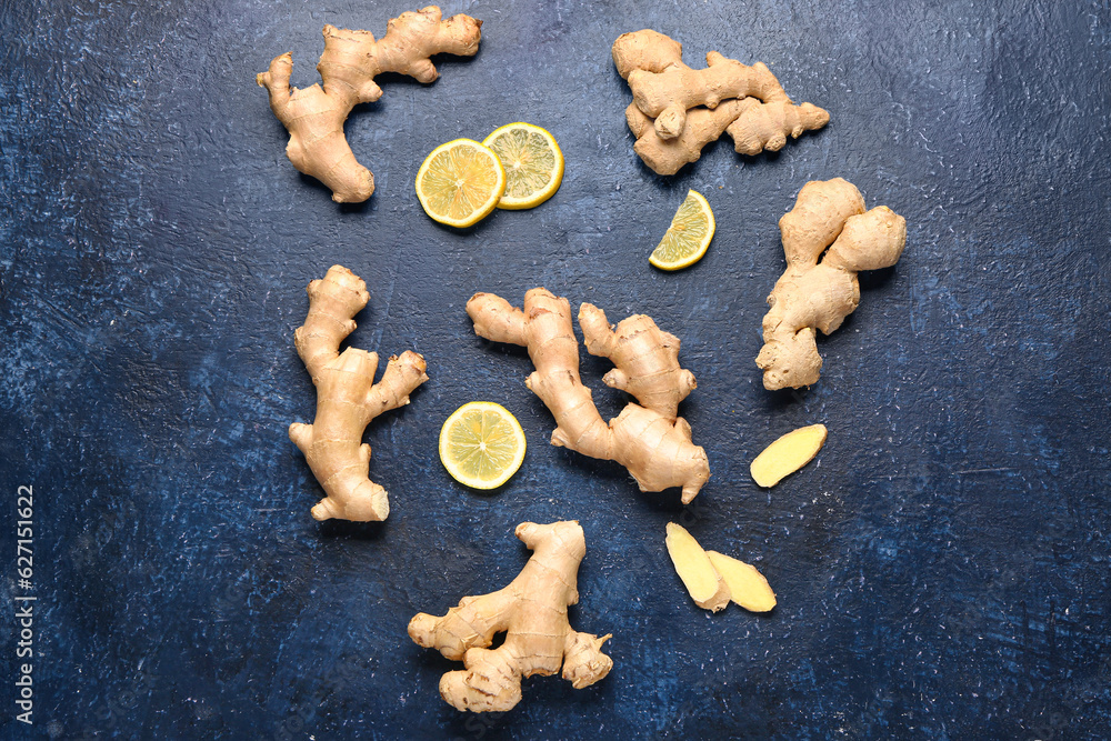 Fresh ginger roots with slices of lemon on blue background