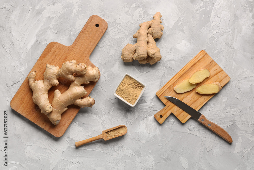 Fresh ginger roots and bowl with dried powder on grey background