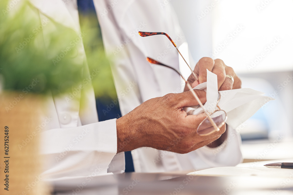 Hands, healthcare and an optometrist cleaning glasses in his office for vision, eyesight or hygiene.