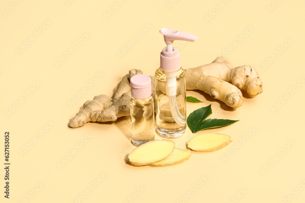 Bottles of ginger cosmetic oil and leaves on yellow background