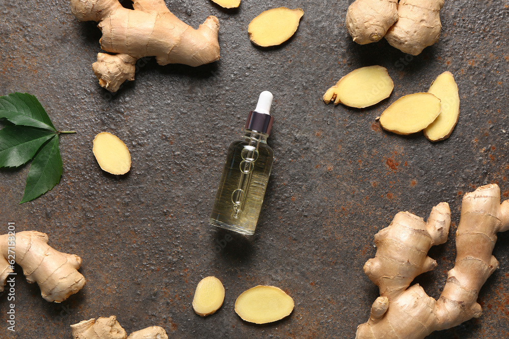 Bottle of ginger cosmetic oil and leaves on dark background