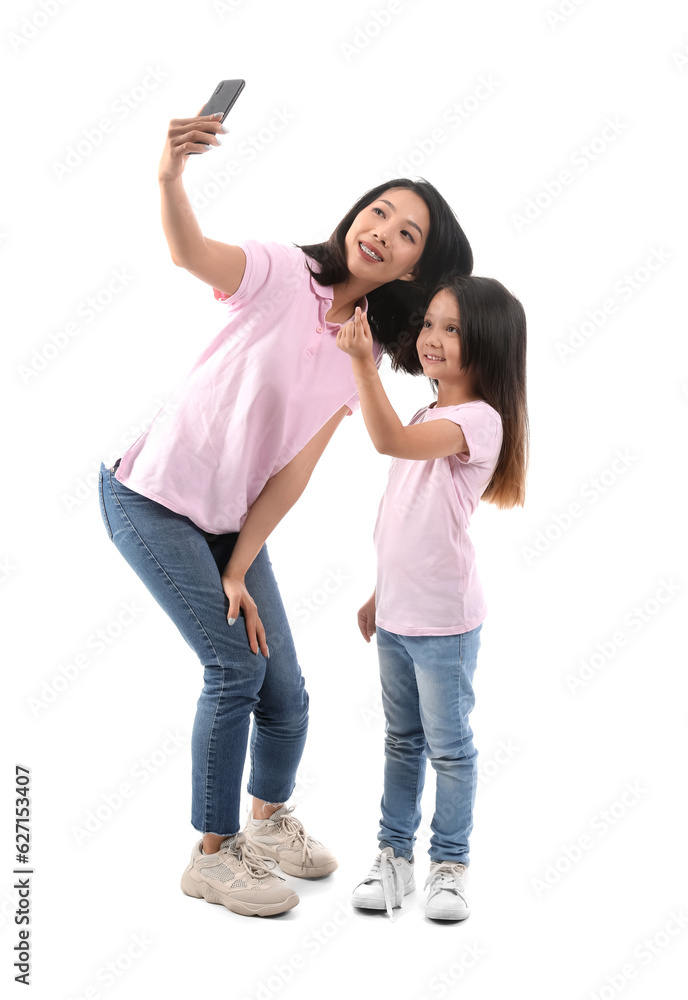 Asian mother with her little daughter taking selfie on white background