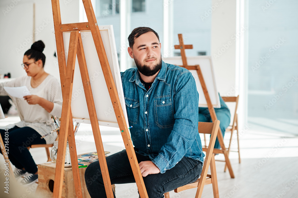 I wonder what colour I should use. Cropped shot of a handsome young artist sitting and looking conte