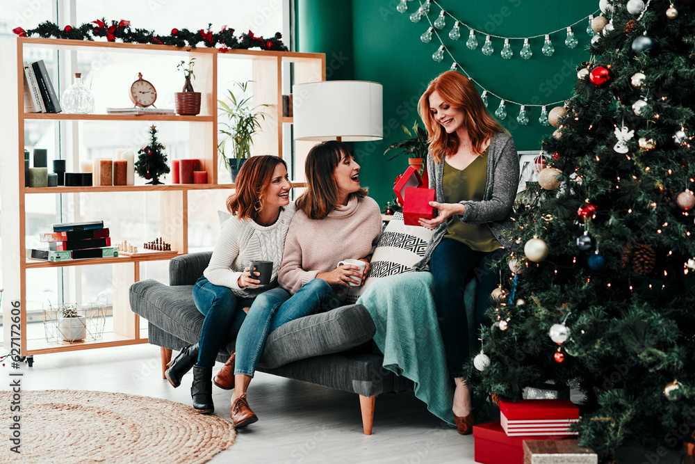 You guys shouldt have. Shot of three attractive middle aged women opening presents together while be