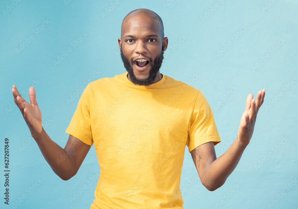 Portrait, wow and surprise with a black man in studio on a blue background feeling shocked or in awe