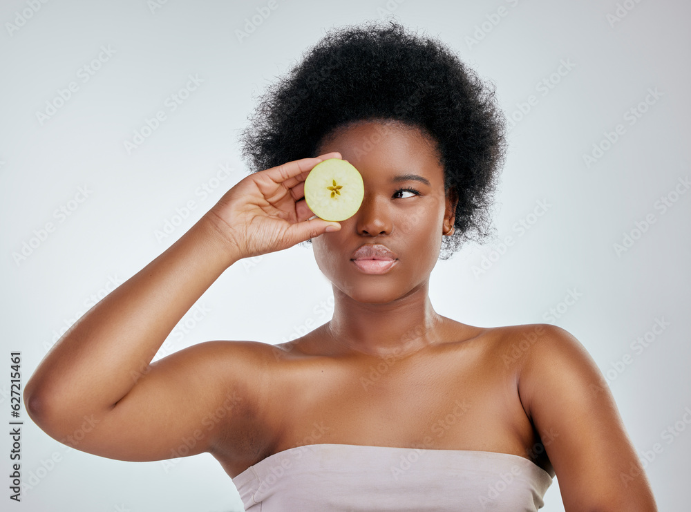 Black woman, apple and afro for diet, natural nutrition or health against a white studio background.