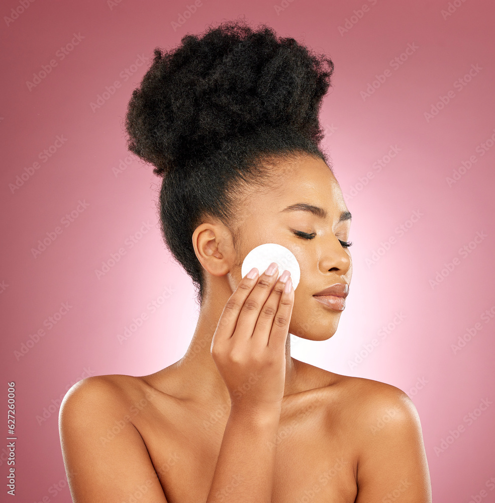 Black woman, cotton pad and dermatology with makeup, facial and salon treatment on a studio backgrou