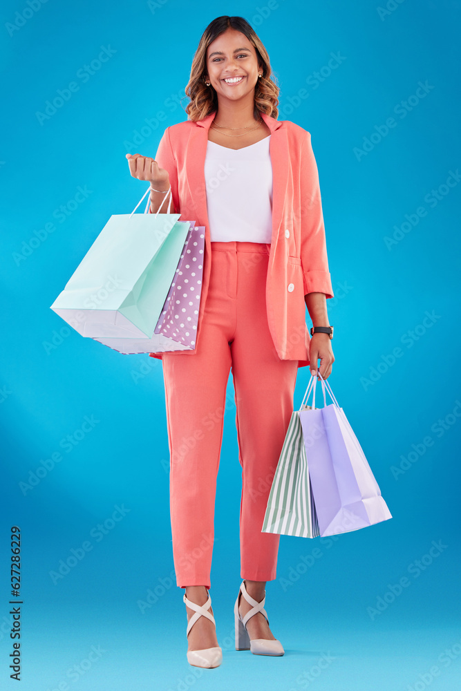 Portrait, fashion and shopping bags with a woman customer in studio on a blue background for consume