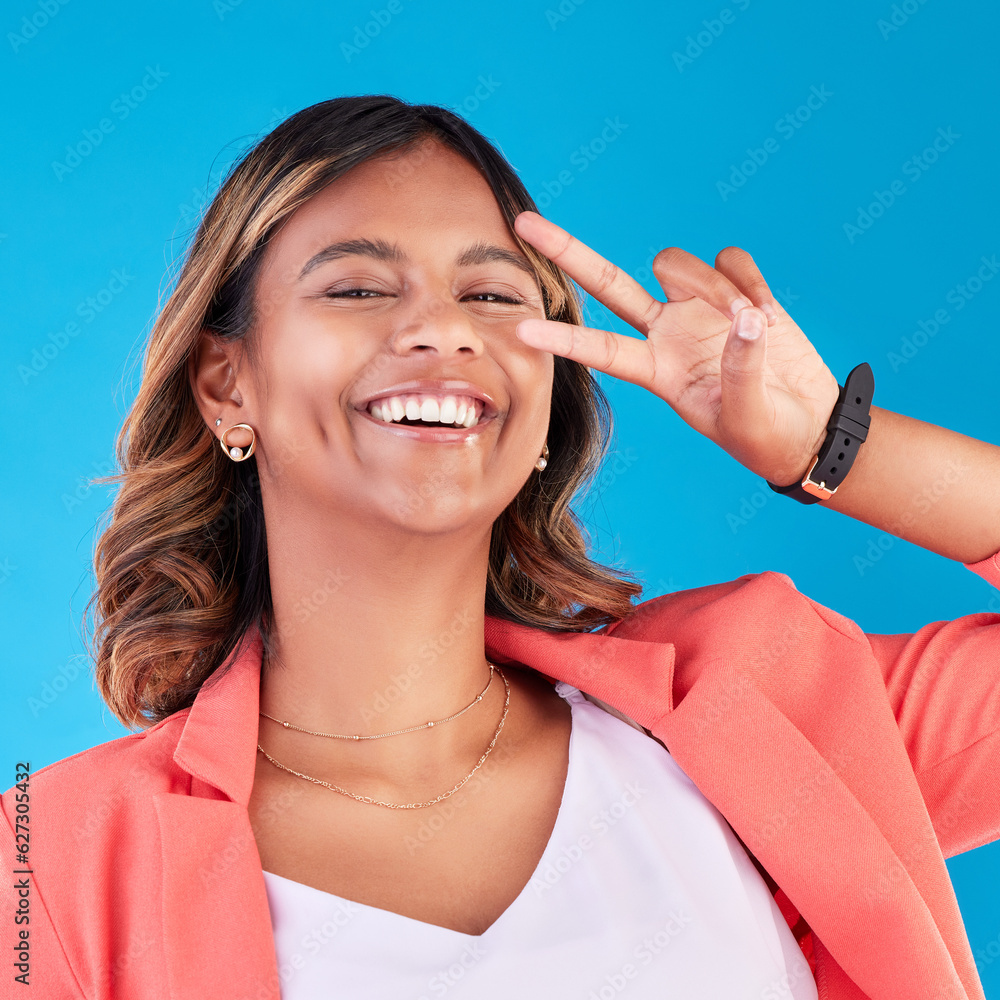 Peace sign, happy and portrait of a woman on a blue background for fashion, comedy and young. Smile,