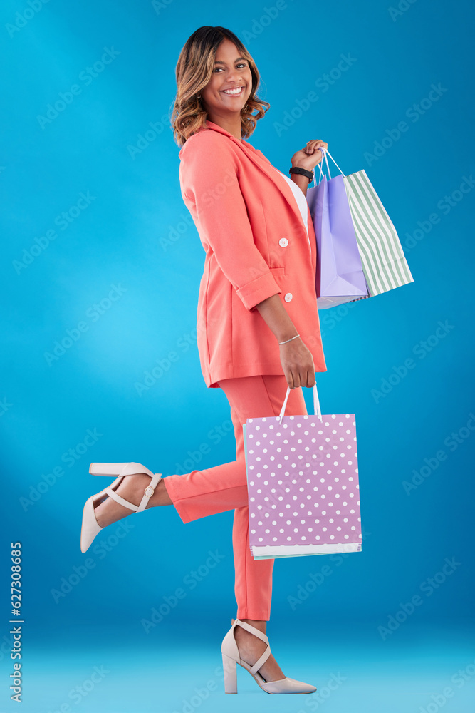 Portrait, fashion and shopping with a woman customer in studio on a blue background for discount. Sm