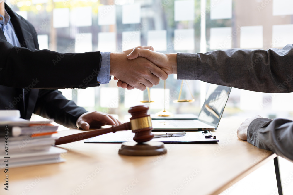 Businessman shaking hands to seal a deal with his partner lawyers or attorneys discussing a contract