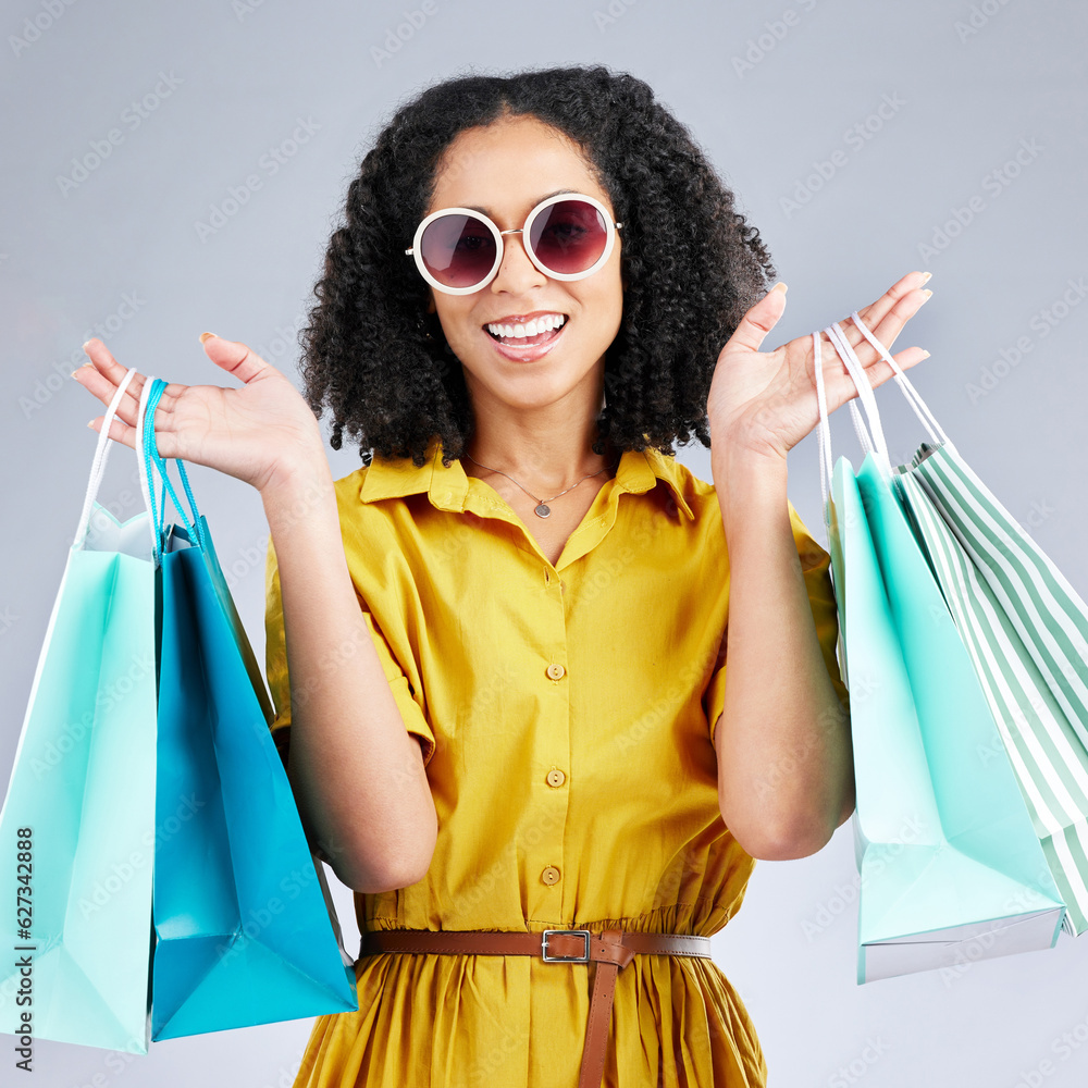 Portrait, sunglasses and woman with shopping bags for fashion in studio isolated on a white backgrou