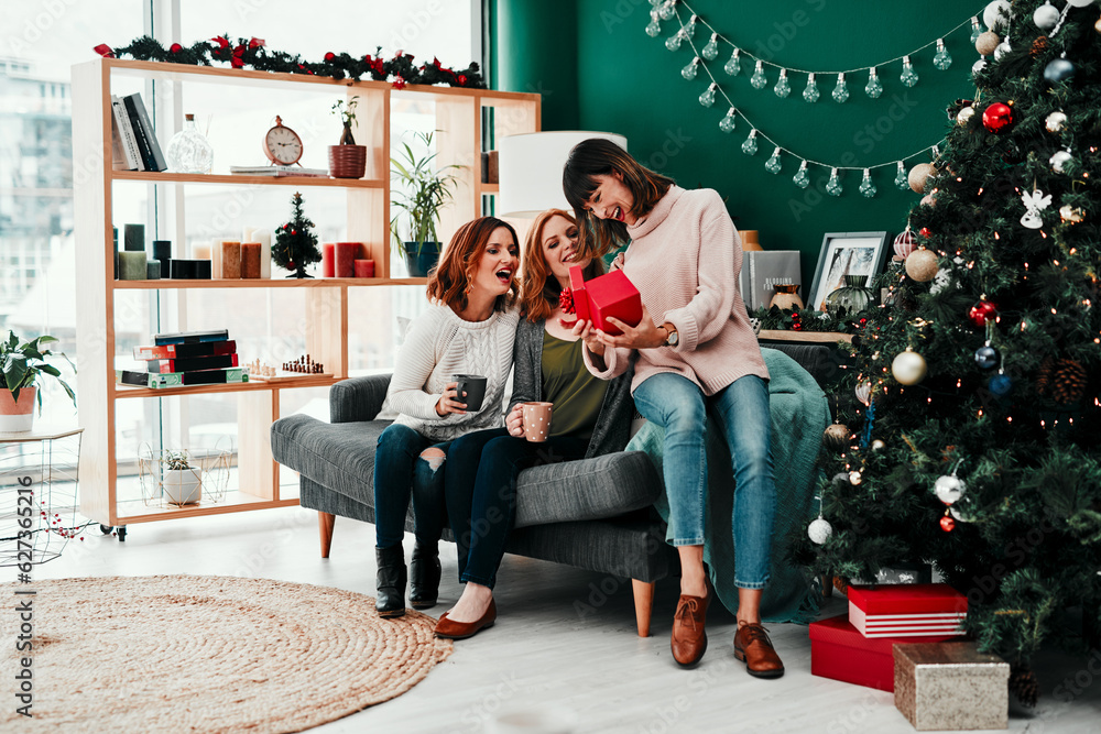 Thank you both very much. Shot of three attractive middle aged women opening presents together while