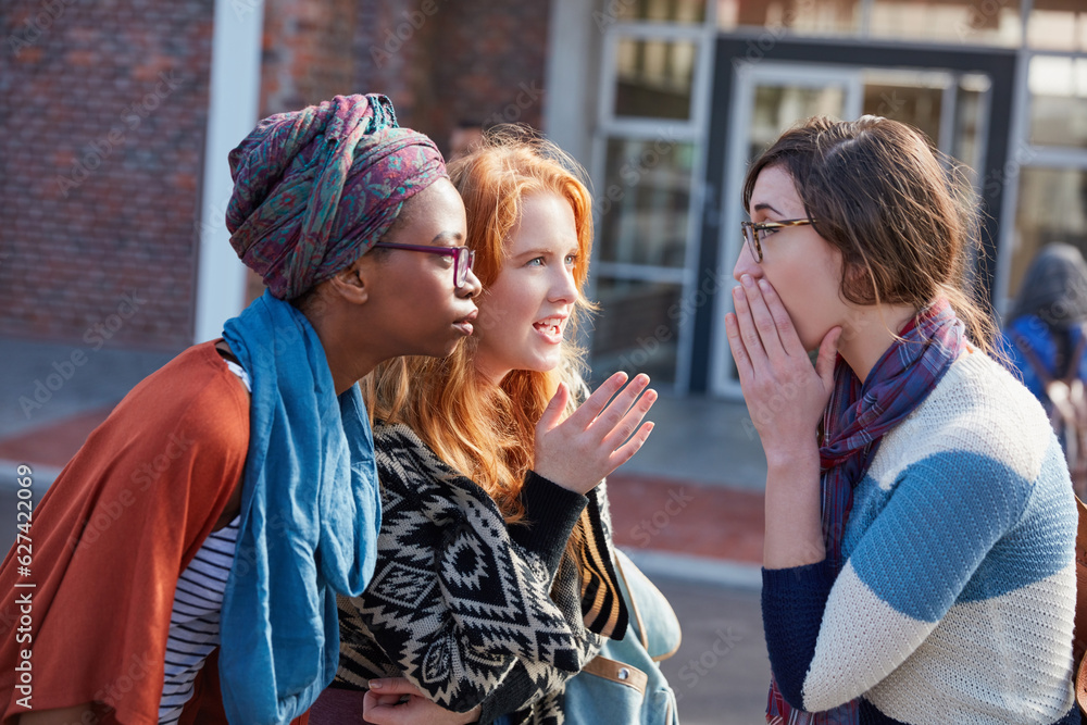 Youll never guess what I just heard. Cropped shot of a group of university students hanging out betw