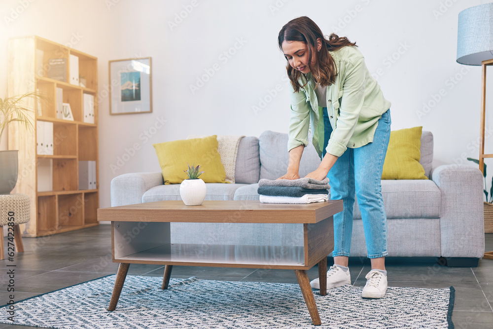 Woman, home and laundry on living room table for hygiene, cleaning and folding for housework in morn