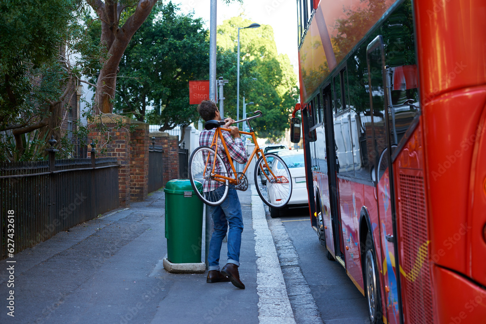 En route to work. Shot of a man with his bicycle at a bus stop.