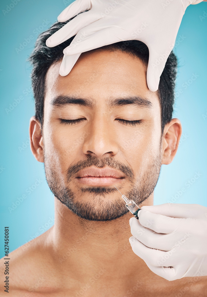 Face, hands and botox with a plastic surgery man in studio on a blue background for beauty enhanceme