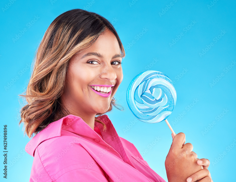 Woman, lollipop and smile in studio portrait with eating, sweets and excited for food by blue backgr