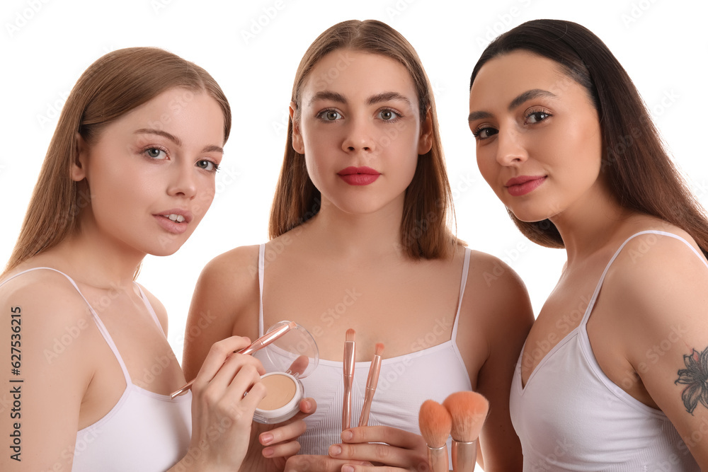 Young women with makeup brushes and powder on white background