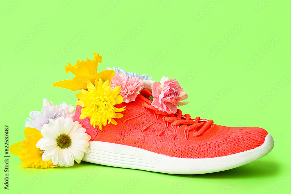 Sneaker with spring flowers on green background